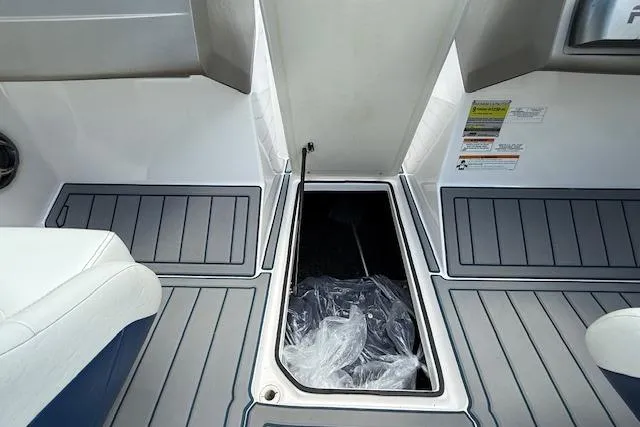 Slide: The Image of 2012 Regal 2000 Bowrider interior storage compartment with open hatch and seating. - 24