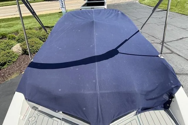 Slide: The Image of 2012 Regal 2000 Bowrider with blue cover, parked on paved driveway. - 30