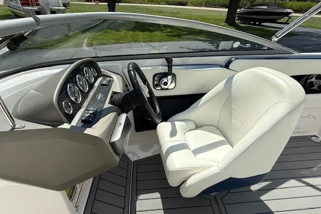 Slide: The Image of Interior of a 2012 Regal 2000 Bowrider boat with white seating and dashboard controls. - 6