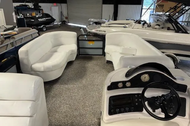 Slide: The Image of Interior of a 2002 Aqua Patio AP 220 R pontoon boat with white seating and control panel. - 12