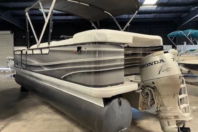 Slide: The Image of 2002 Aqua Patio AP 220 R pontoon boat with Honda outboard motor in a storage facility. - 6