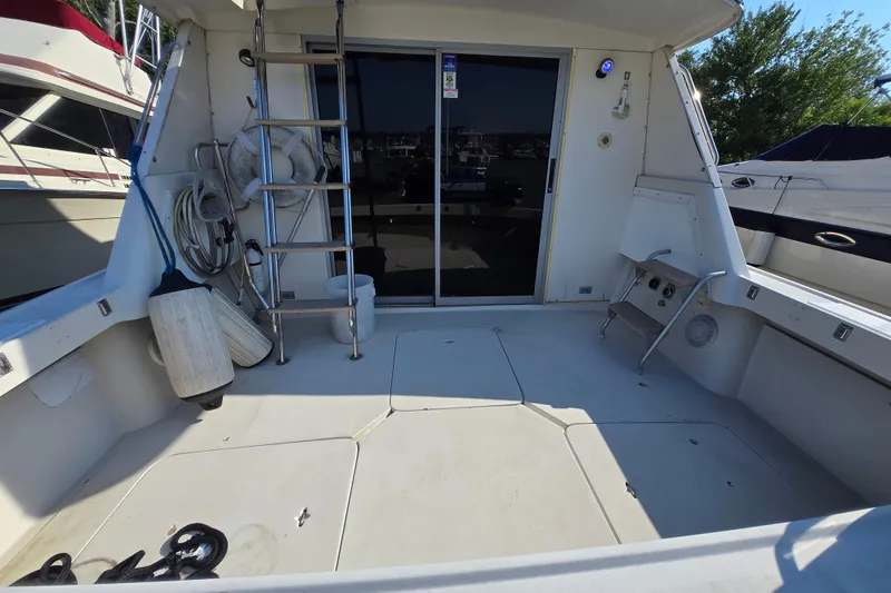 Slide: The Image of 1987 Silverton 34C boat deck with ladder, ropes, and fenders in a marina setting. - 10