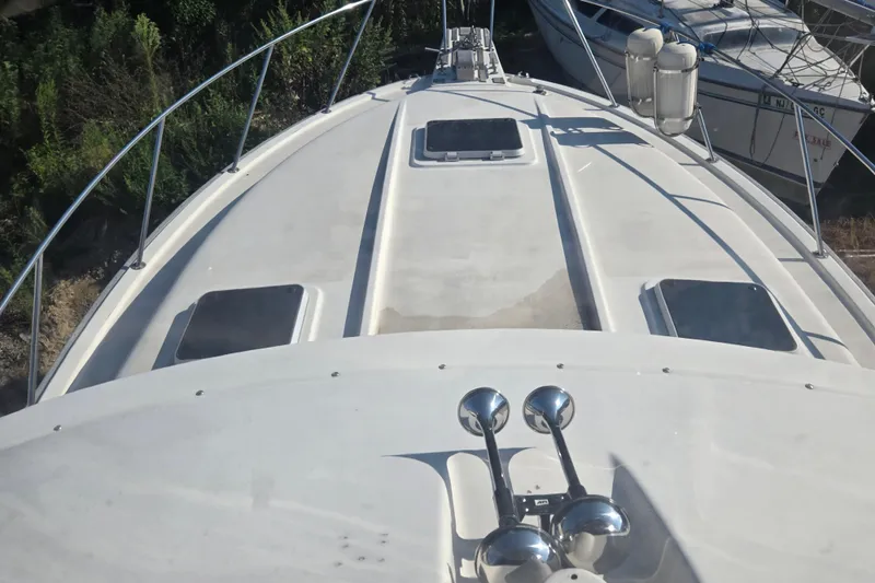 Slide: The Image of 1987 Silverton 34C boat deck with hatches and railing, docked near other vessels. - 12
