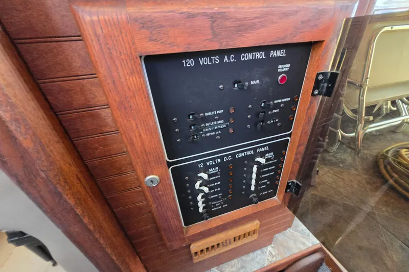 Slide: The Image of 1987 Silverton 34C electrical control panel with wood finish, featuring AC and DC switches. - 16
