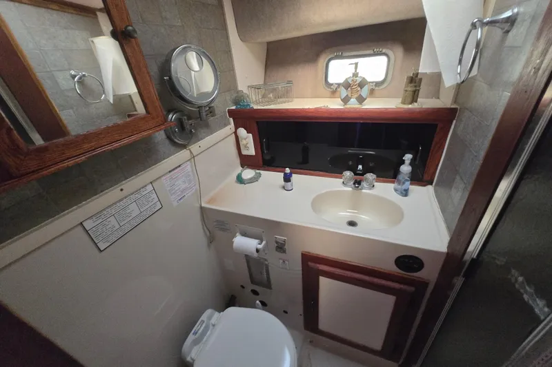 Slide: The Image of 1987 Silverton 34C bathroom with sink, mirror, and toiletries. - 18
