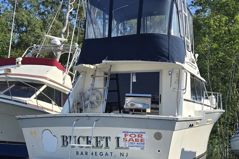 Slide: The Image of 1987 Silverton 34C boat for sale, docked in Barnegat, NJ, with blue canopy. - 2
