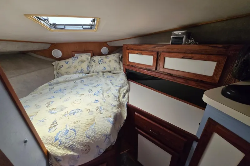Slide: The Image of Cozy cabin interior of 1987 Silverton 34C with nautical-themed bedding and wooden storage cabinets. - 22