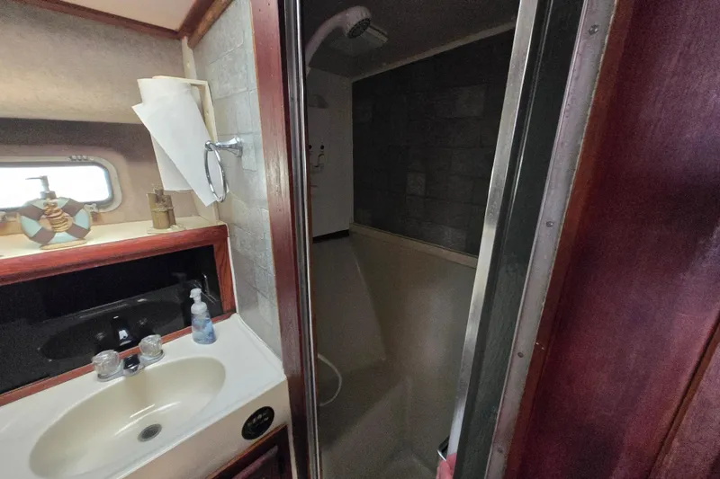 Slide: The Image of Bathroom interior of 1987 Silverton 34C boat with sink and shower. - 25