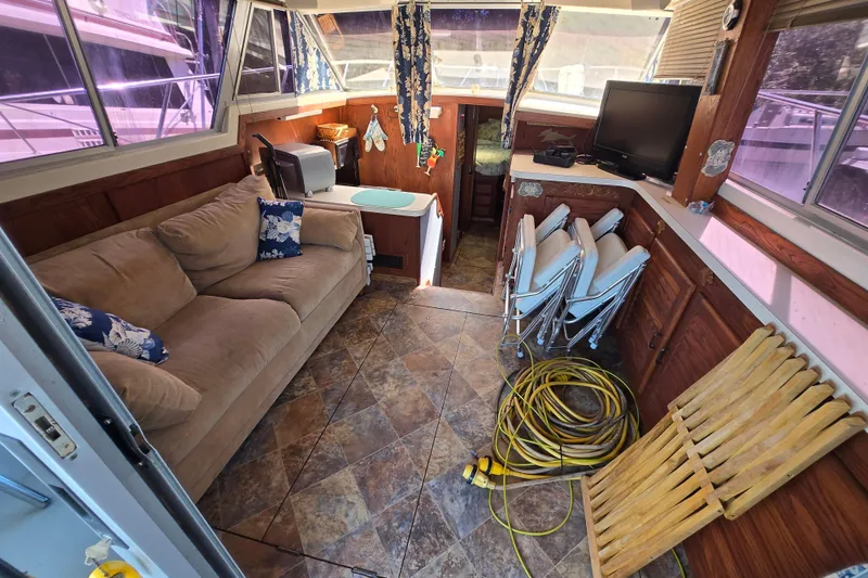 Slide: The Image of Interior of a 1987 Silverton 34C boat with sofa, TV, and folding chairs. - 4