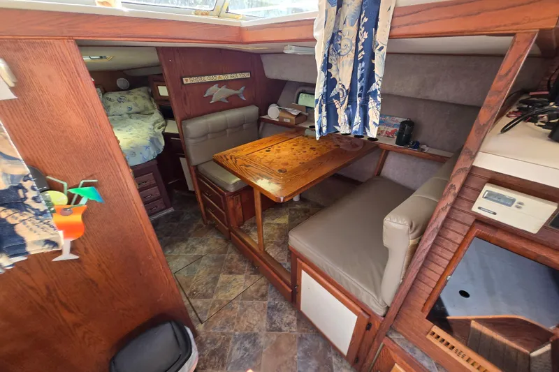 Slide: The Image of 1987 Silverton 34C yacht interior with cozy dining area and wood accents. - 5