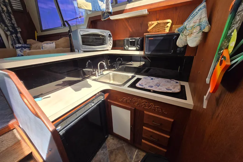 Slide: The Image of 1987 Silverton 34C yacht kitchen with sink, microwave, and toaster oven. - 7