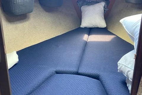 Slide: The Image of 1985 O'Day 28 sailboat interior cabin with blue cushions and pillows. - 10