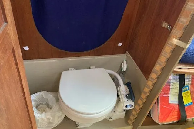 Slide: The Image of 1985 O'Day 28 sailboat bathroom with marine toilet and wooden interior. - 11