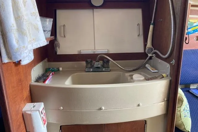 Slide: The Image of 1985 O'Day 28 sailboat bathroom with sink, faucet, and storage cabinets. - 12