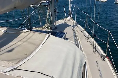 Slide: The Image of 1985 O'Day 28 sailboat deck with rigging and solar panel on calm water. - 17