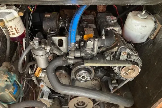 Slide: The Image of Engine compartment of a 1985 O'Day 28 sailboat, showcasing mechanical components and hoses. - 19