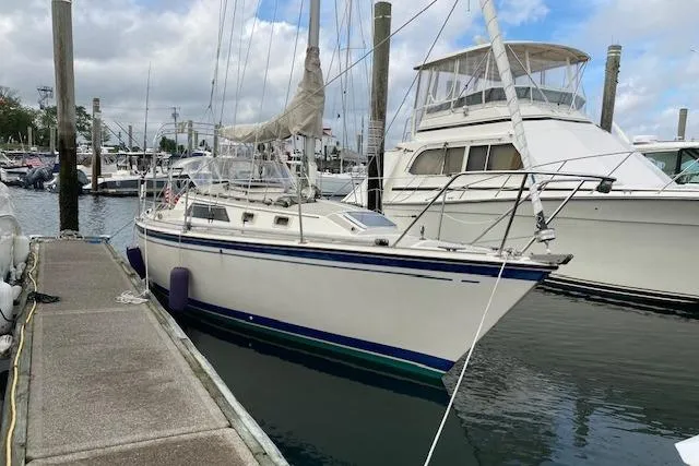 Slide: The Image of 1985 O'Day 28 sailboat docked at marina, featuring white hull and blue accents. - 2