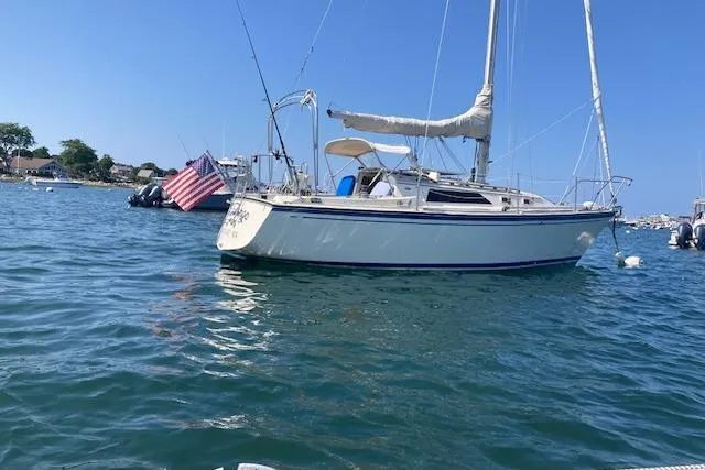 Slide: The Image of 1985 O'Day 28 sailboat on calm water with American flag, clear blue sky. - 4