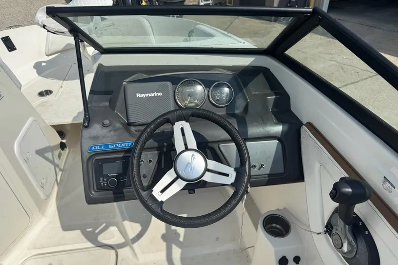 Slide: The Image of 2017 Sea Ray SPX 190 Outboard boat interior with cushioned seating and cup holders. - 13