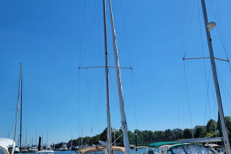 Slide: The Image of Sailboats docked under clear blue sky, featuring a 1999 Beneteau Oceanis 351. - 11