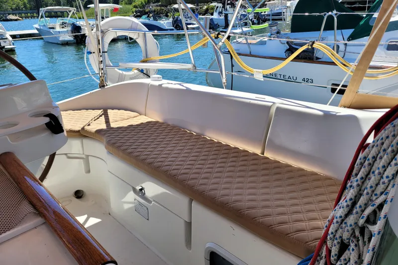 Slide: The Image of 1999 Beneteau Oceanis 351 sailboat cockpit with cushioned seating at marina. - 15