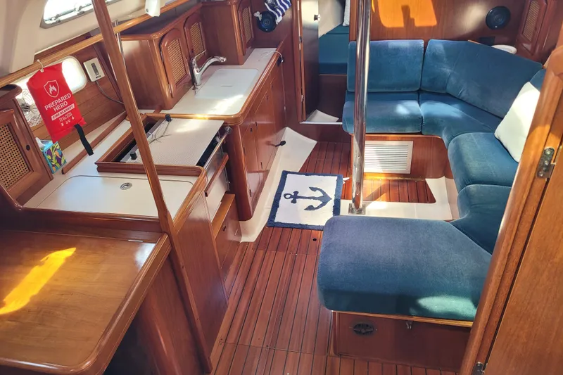 Slide: The Image of Interior of 1999 Beneteau Oceanis 351 yacht with wood finish and blue seating. - 24