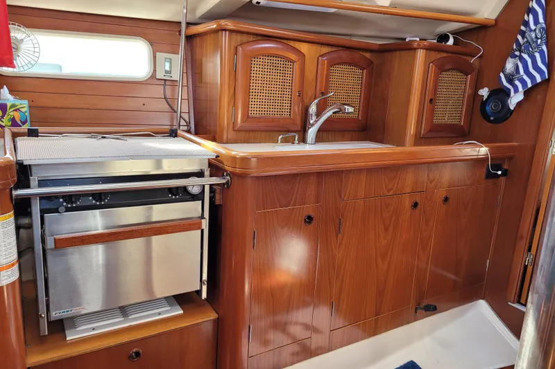 Slide: The Image of Interior of 1999 Beneteau Oceanis 351 yacht kitchen with wood cabinetry and stainless steel oven. - 26