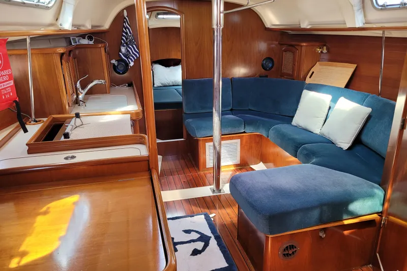 Slide: The Image of Interior of 1999 Beneteau Oceanis 351 sailboat with blue seating and wooden finishes. - 27