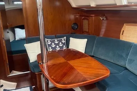 Slide: The Image of Interior of 1999 Beneteau Oceanis 352 sailboat with wooden table and blue seating. - 28