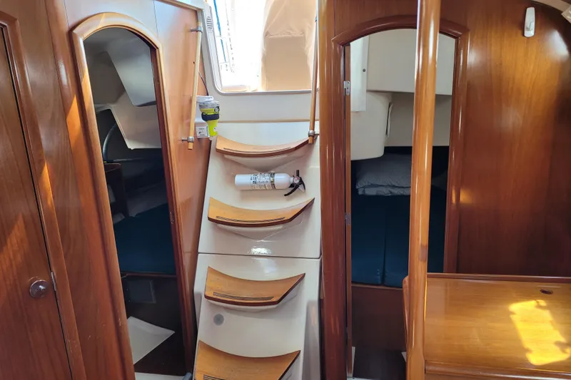 Slide: The Image of Interior of 1999 Beneteau Oceanis 351 sailboat with wooden cabinetry and stairs. - 34