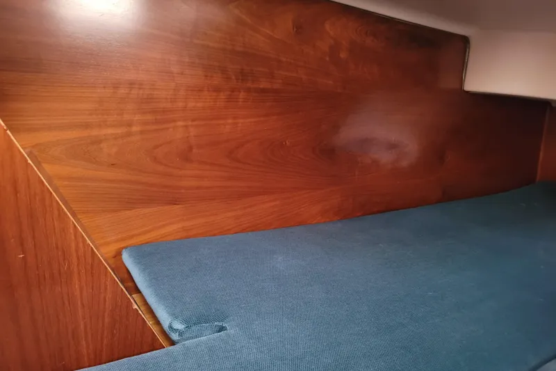 Slide: The Image of Interior cabin of 1999 Beneteau Oceanis 351 with wooden paneling and blue cushion. - 36