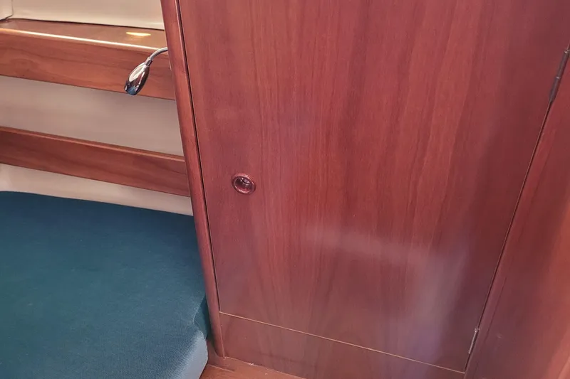 Slide: The Image of Interior cabin of 1999 Beneteau Oceanis 351 sailboat with wooden paneling and blue seating. - 37