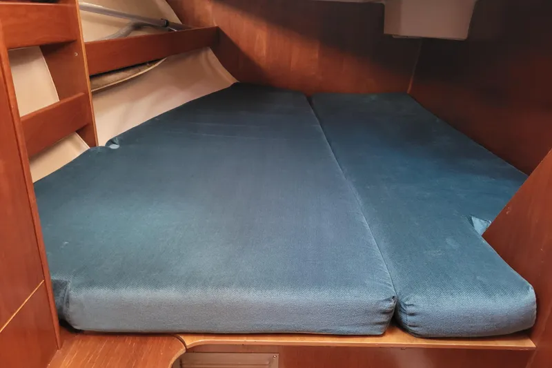 Slide: The Image of 1999 Beneteau Oceanis 351 cabin interior with blue cushions and wooden finish. - 38