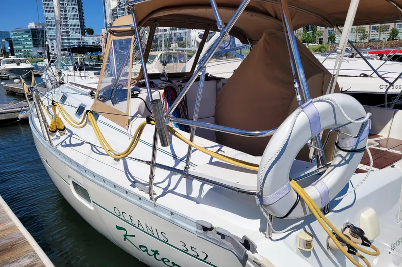 Slide: The Image of 1999 Beneteau Oceanis 351 sailboat docked at marina, featuring lifebuoy and canopy. - 4