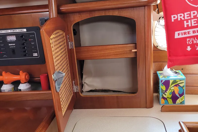 Slide: The Image of Interior of a 1999 Beneteau Oceanis 351 sailboat with open cabinet and control panel. - 48
