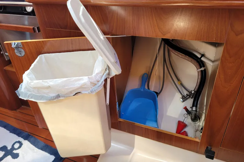 Slide: The Image of Interior of 1999 Beneteau Oceanis 351 showing trash bin and storage compartment. - 51