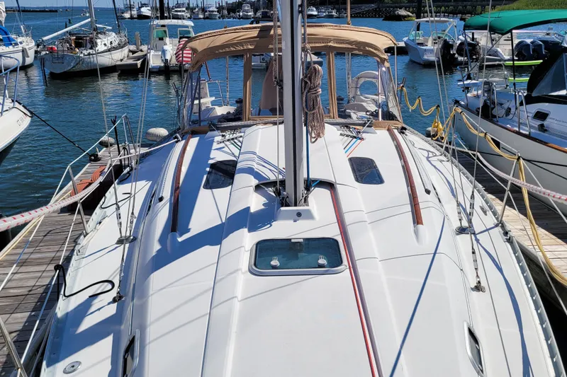 Slide: The Image of 1999 Beneteau Oceanis 351 sailboat docked in a marina, surrounded by other boats. - 7