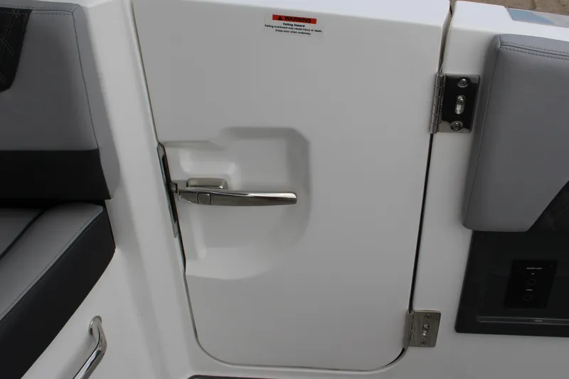 Slide: The Image of 2025 Cobalt R35 boat interior door with sleek handle and cushioned seating. - 10