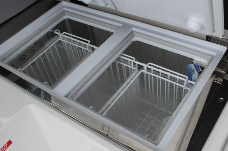 Slide: The Image of Dual-compartment freezer in 2025 Cobalt R35 boat, featuring wire baskets and sleek design. - 13