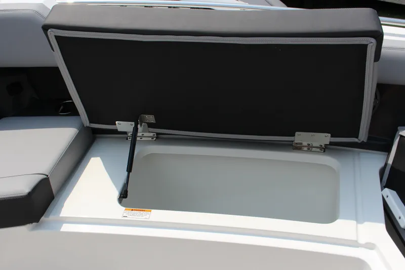 Slide: The Image of Open storage compartment in 2025 Cobalt R35 boat, featuring cushioned seating and hydraulic support. - 24