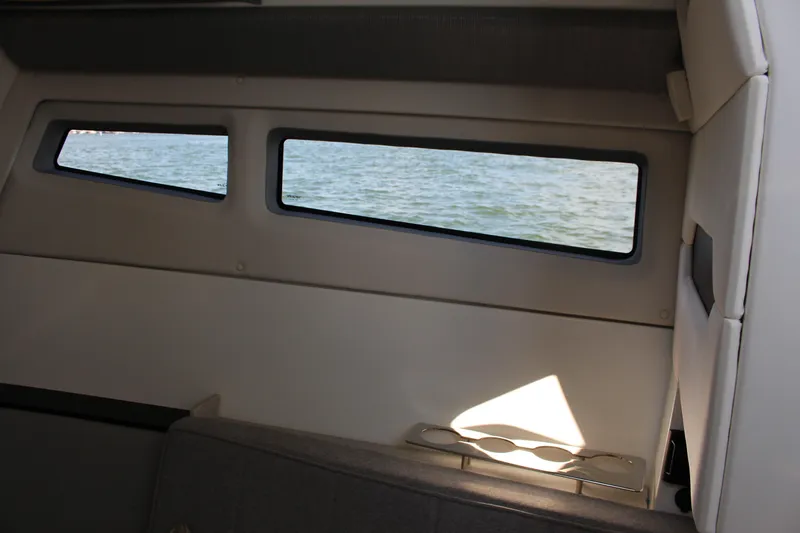 Slide: The Image of Interior view of 2025 Cobalt R35 boat, showcasing windows with a scenic water view. - 43