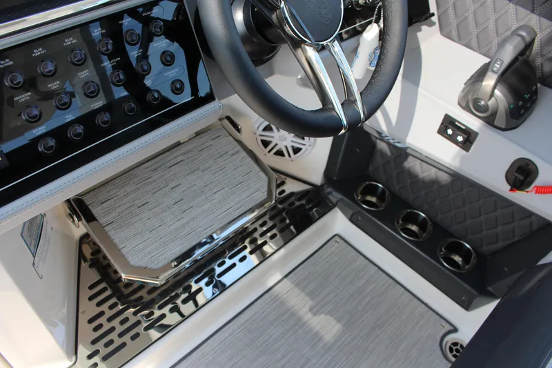 Slide: The Image of 2025 Cobalt R35 boat cockpit with steering wheel, control panel, and cup holders. - 45