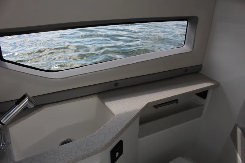 Slide: The Image of Interior of 2025 Cobalt R35 boat with sink and water view through window. - 52