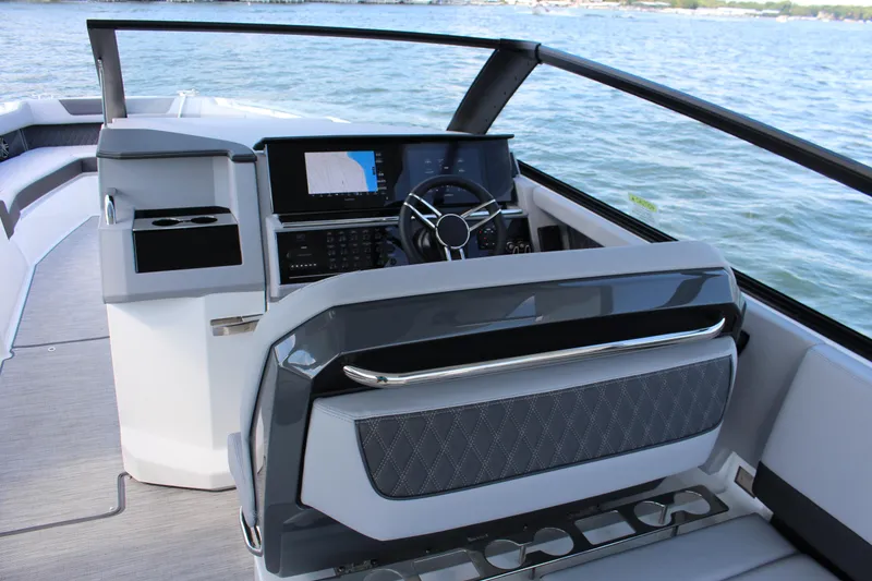 Slide: The Image of 2025 Cobalt R35 boat cockpit with modern steering and navigation system on open water. - 56
