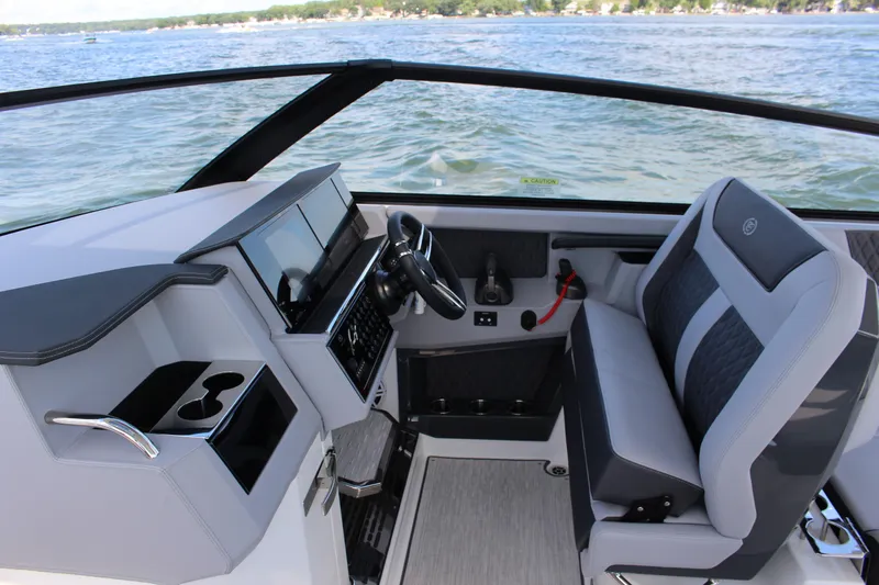 Slide: The Image of 2025 Cobalt R35 boat interior with modern dashboard and seating, overlooking a scenic lake. - 57