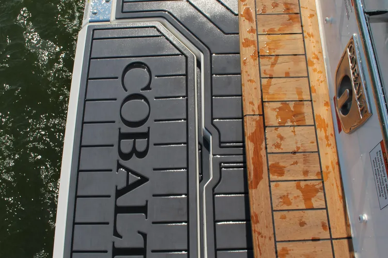 Slide: The Image of 2025 Cobalt R35 boat deck with logo, featuring wet wooden and rubber surfaces. - 78