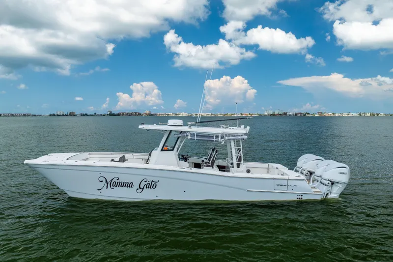 Slide: The Image of 2022 World Cat 400 CC-X boat on water under blue sky with clouds. - 0