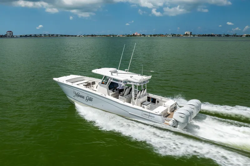 Slide: The Image of 2022 World Cat 400 CC-X boat cruising on green water under a blue sky. - 11