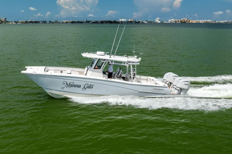 Slide: The Image of 2022 World Cat 400 CC-X boat cruising on green water under a blue sky. - 12
