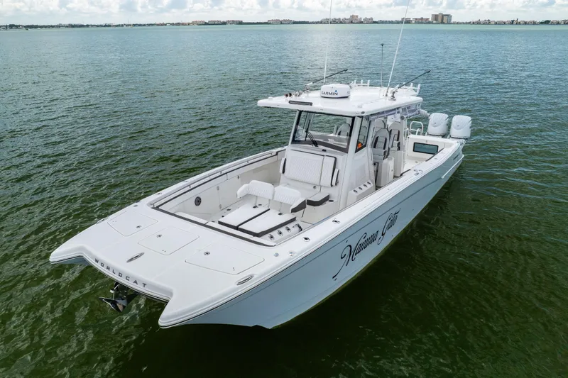 Slide: The Image of 2022 World Cat 400 CC-X boat on calm water, showcasing sleek design and spacious deck. - 2